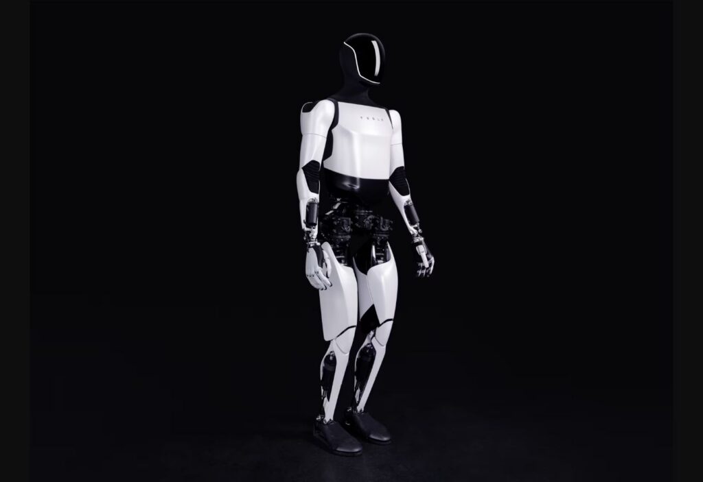 Tesla Optimus humanoid robot standing against a dark background